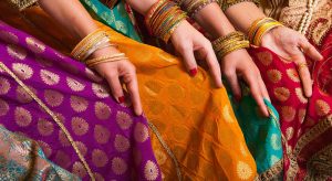 Bollywood dancers are holding their vivid costumes. Hands are in a row