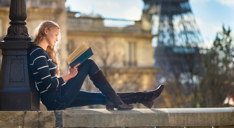 Beautiful young woman in Paris, reading a book