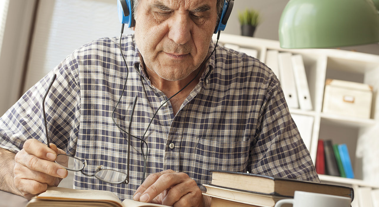 Portrait of old man reading book