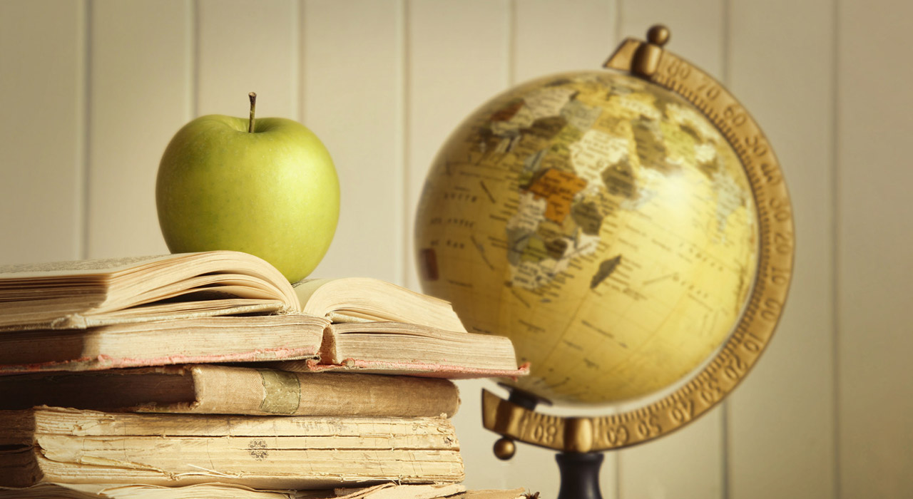 Old books with apple and globe