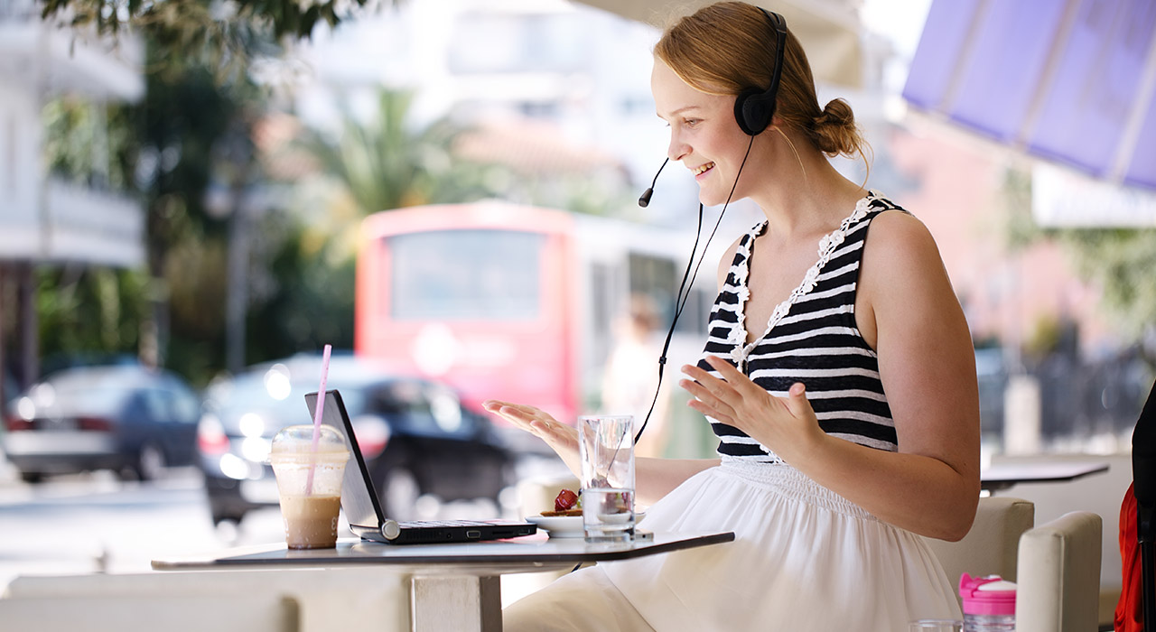 Laughing woman wearing a headset in outdoor cafe