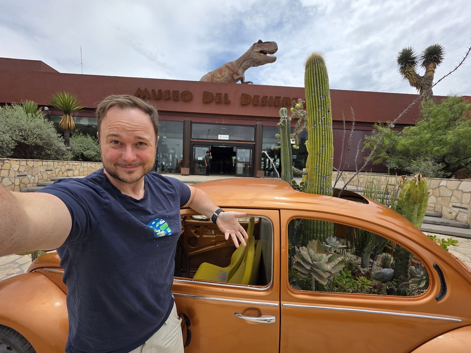 Benny beside an orange Volkswagen Beetle outside the Museo del Desierto in Saltillo, Mexico