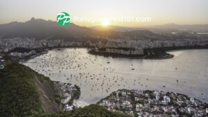 The PortuguesePod101 logo over a sunset view of Rio de Janeiro, with Christ the Redeemer and Botafogo bay