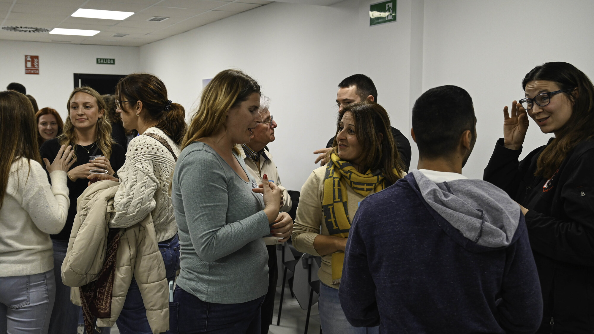 Adults talking in small groups at a Spanish–English language exchange in Rota, Spain.
